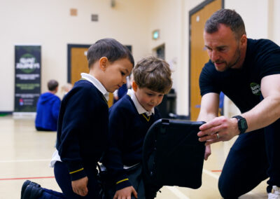 Children being taught by a teacher holding an iPad